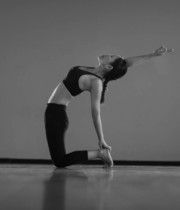Mujer en una postura fluida de yoga, demostrando flexibilidad y calma.